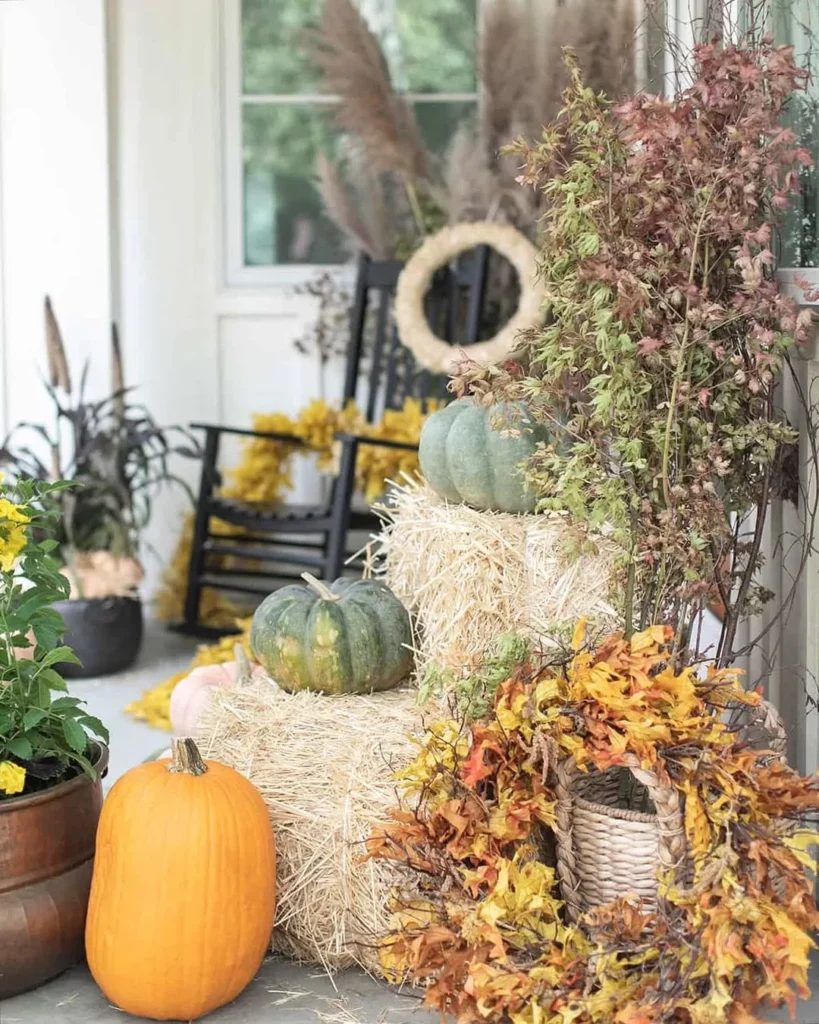 many pumpkins, hay and flowers