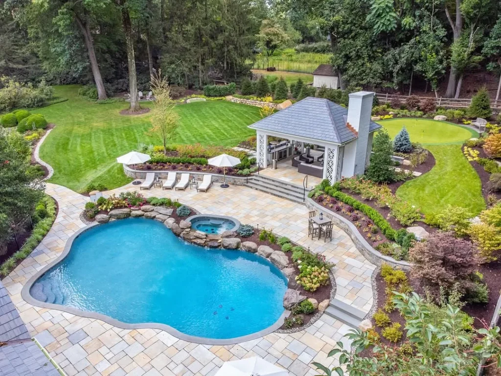 sparkling pool, lush gardens, and multiple outdoor living spaces